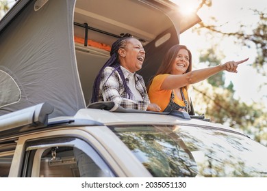 Senior multiracial friends enjoy vacation in the nautre with mini van - Mature women on a road trip with camper