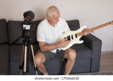 Senior Music Teacher Recording Guitar Lesson At Home