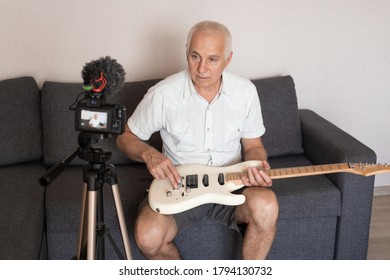 Senior Music Teacher Recording Guitar Lesson At Home