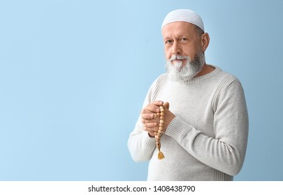 Senior Muslim Man Praying Against Light Background