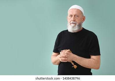 Senior Muslim Man Praying Against Color Background