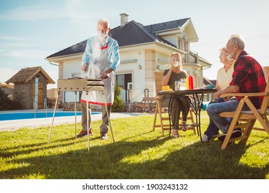 Senior Neighbors Having Fun Spending Sunny Summer Day Together Outdoors, Having A Backyard Barbecue Party By The Swimming Pool