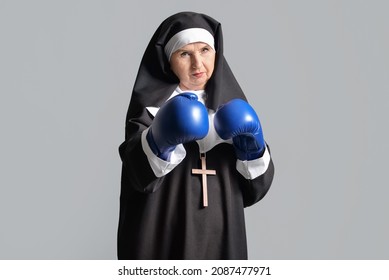 Senior Nun In Boxing Gloves On Grey Background