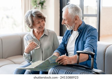 Senior old active couple husband and wife grandparents travelling together, using map to check the route, moving to another place, going on a holiday, voyage with bags and luggage - Powered by Shutterstock