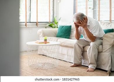 Senior Old Asian Man Feel Stressed, Headache Sitting Alone On Sofa At Home