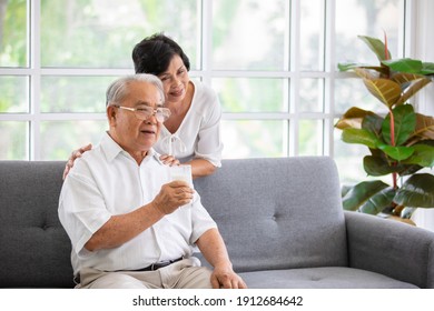 Senior Old Asian Man And Woman Lovers Holding A Glass Of Milk And Drinking Together. Idea For The Healthcare Of Elder People.