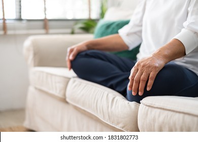 Senior Old Asian Woman Sitting On Sofa Practicing Yoga And Meditation At Home, Retirement And Wellbeing Concept