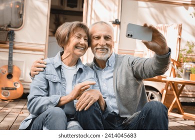 Senior old elderly caucasian mature couple grandparents having videocall conversation online on cellphone while traveling by trailer motor home camper van - Powered by Shutterstock