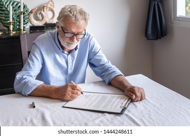 Senior old man elderly examining and signing last will and testament