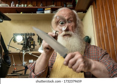 Senior old man looking through zoom magnifying glass. Funny elder amazement investigation old man knife sharpening master profession - Powered by Shutterstock