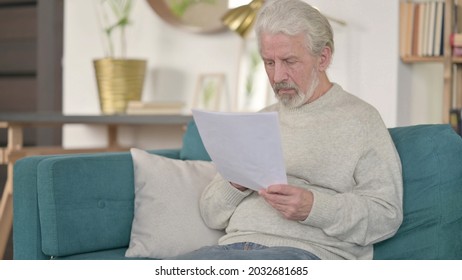 Senior Old Man Reading Documents At Home