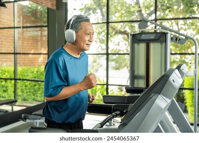 Senior old man runner exercise indoor gym. fitness man jogging wearing sportswear. Mature athlete man in sportswear Workout running on the treadmill.