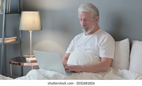 Senior Old Man Using Laptop In Bed