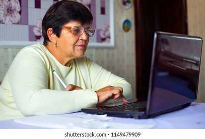 Senior Old Woman In Eyeglasses Surfing Internet On Laptop At Home. White Caucasian Female Pensioner Using Computer Shopping Online. Technology, Communication, Information Concept