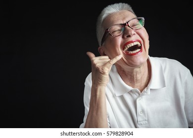 Senior Old Woman Pretending To Talk On A Cell Phone, Pulling A Prank, Laughing Cordially