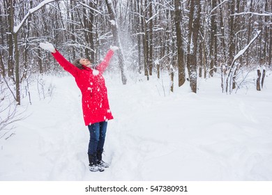 Senior Old Woman Throws Snow In The Wood In Red Coat