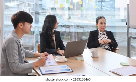 Senior Older Female Executive Ceo And Young Employee Discuss Corporate Project At Boardroom