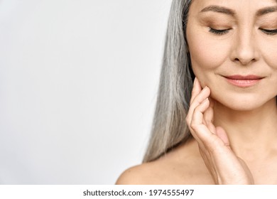 Senior Older Middle Aged Asian Woman With Grey Hair And Radiant Face With Perfect Skin. Advertising Of Rejuvenating Skincare And Makeup For Natural Radiant Glow And Healthy Skin. Copy Space.