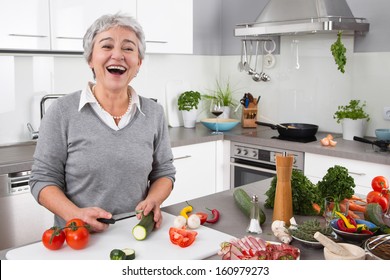 Senior Or Older Woman With Grey Hair Cooking In Kitchen - Vegetables