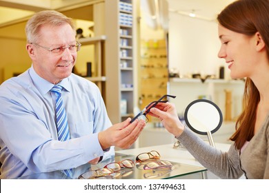 Senior optician selling new glasses to a young female customer - Powered by Shutterstock