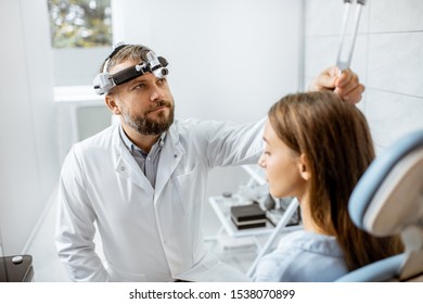 Senior otolaryngologist examining ears with ENT tuning fork for a young patient in the medical office. Hearing test with tuning fork concept - Powered by Shutterstock