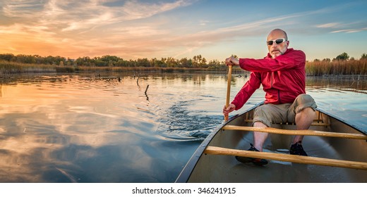 senior paddler enjoying paddling a canoe on a calm lake at sunset, Riverbend Ponds Natural Area, Fort Collins, Colorado - Powered by Shutterstock