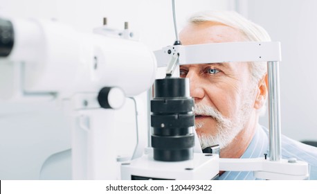 Senior patient checking vision with special eye equipment
