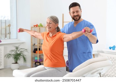 Senior patient exercising under physiotherapist supervision in rehabilitation center - Powered by Shutterstock