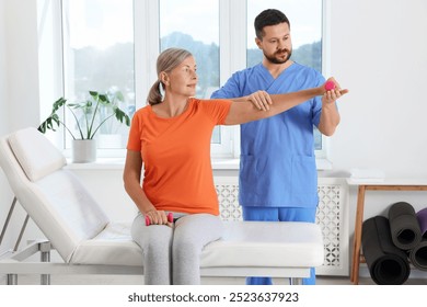 Senior patient exercising under physiotherapist supervision in rehabilitation center - Powered by Shutterstock