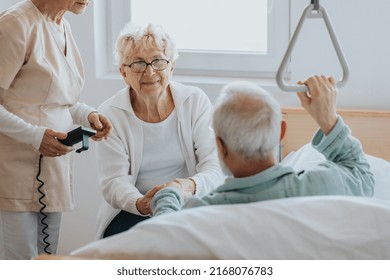 Senior patient gets up from the hospital bed by helping himself with a special handle - Shutterstock ID 2168076783