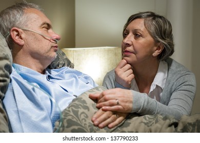 Senior patient at hospital with worried wife holding hands - Powered by Shutterstock