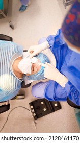 Senior Patient Laying Down And Waiting For A Doctor To Put An Eye Patch After A Successful Cataract Operation