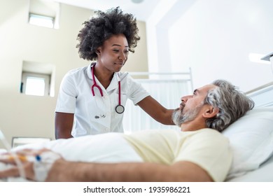 Senior Patient On Bed Talking To African American Female Doctor In Hospital Room, Health Care And Insurance Concept. Doctor Comforting Elderly Patient In Hospital Bed Or Counsel Diagnosis Health.