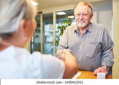 Senior as a patient on greeting with a handshake at reception at the doctor or physiotherapist - Powered by Shutterstock