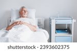 Senior patient rests while lying on the bed, recovering in modern hospital ward. Hospitalization. Treatment and healing. Coronavirus and pandemic concept