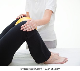 Senior Patient Undergoing Rehabilitation With A Yellow Ball