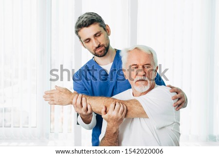 Senior patient while exercise treatment with his physiotherapist. Rehab at medical center