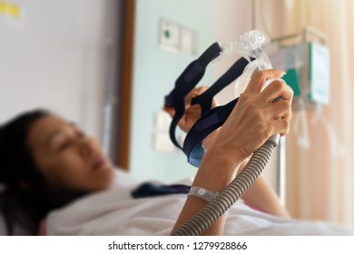 Senior Patient Woman Hands Holding Cpap Mask  Lying  In Hospital Room.
Obstructive Sleep Apnea Therapy.