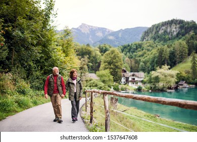 A Senior Pensioner Couple Hiking In Nature, Holding Hands.