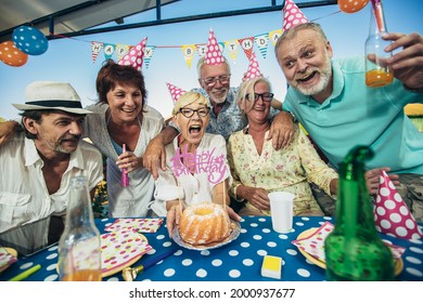 Senior people celebrating birthday in the cottage on the river having fun. - Powered by Shutterstock