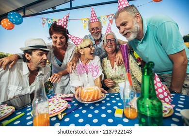 Senior people celebrating birthday in the cottage on the river having fun. - Powered by Shutterstock