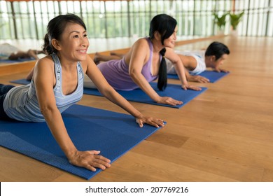 Senior People Doing Cobra Pose At The Yoga Class