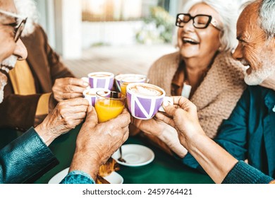 Senior people group toasting latte at coffee bar rooftop - Happy aged friends having fun together sitting at cappuccino restaurant - Life style concept with smiling men and women at cafe terrace - Powered by Shutterstock