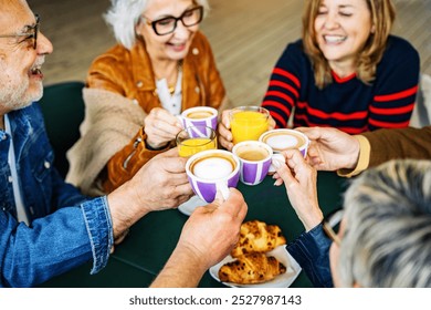 Senior people group toasting latte at coffee bar rooftop - Happy aged friends having fun together sitting at cappuccino restaurant - Life style concept with smiling men and women at cafe terrace - Powered by Shutterstock