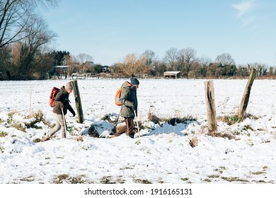 Senior People Hiking Outdoors In Winter. Active Mature Couple Walking In The Snow