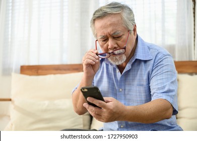 Konzept des Lebensstil-Gesundheitsproblems für Senioren: Portrait Foto von Senioren asiatischen Mann hat ein Auge lang gesichtet Problem zu versuchen, Nachrichten von Smartphone zu lesen.