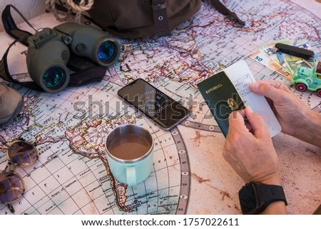 Senior people planning vacation trip on a world map checking passport. Money and travel accessories - active retired elderly concept