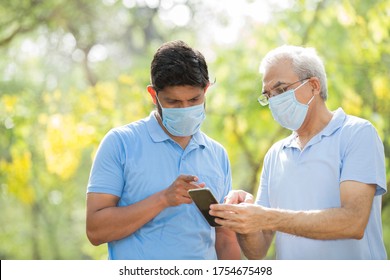 Senior People With Pollution Masks Outside Informing On Smart Phone About Diseases.