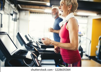 Senior People Running In Machine Treadmill At Fitness Gym Club