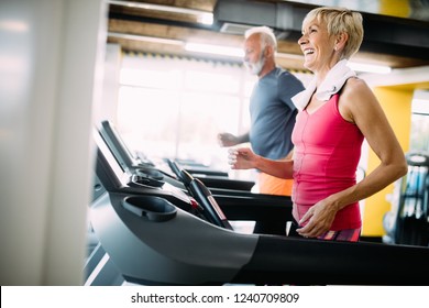 Senior People Running In Machine Treadmill At Fitness Gym Club